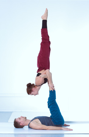 Young athletic couple practicing acroyoga. Balancing in pair.の写真素材