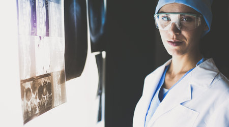 Image of attractive woman doctor looking at x-ray results.