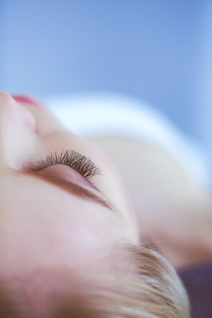 Young woman lying on a massage table,relaxing with eyes closed. Woman. Spa salonの写真素材