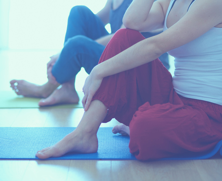 Beautiful couple in sports clothes is meditating.の写真素材