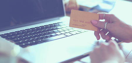 Young woman holding credit card and using laptop computer. Online shopping concept.の写真素材