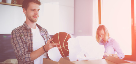 Couple unpacking cardboard boxes in their new home. Young couple.の写真素材