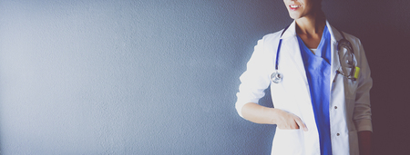 Portrait of young woman doctor with white coat standing in hospital.の写真素材