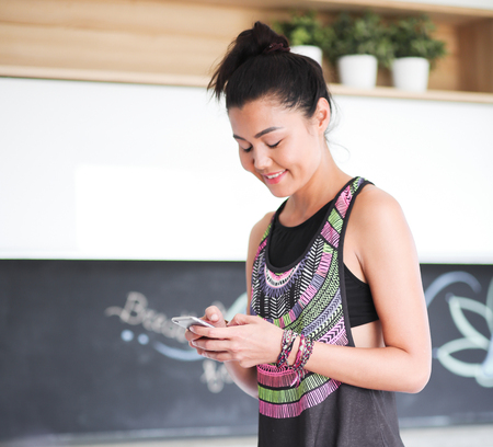Portrait of a beautiful sports woman using smartphoneの写真素材