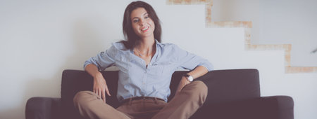 Portrait of happy young woman sitting on sofa