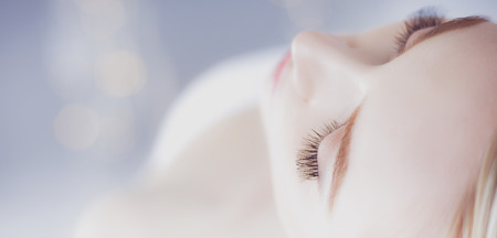 Young woman lying on a massage table,relaxing with eyes closed. Woman. Spa salonの写真素材