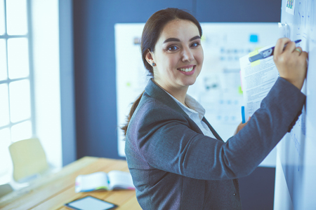 Business, education and office concept - business team with flip board in office discussing somethingの写真素材