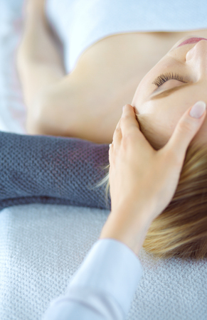 Young woman lying on a massage table,relaxing with eyes closed. Woman. Spa salonの写真素材
