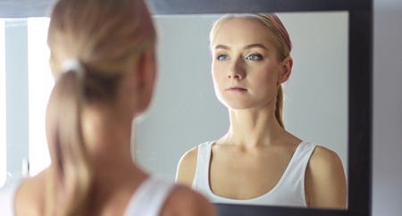 The beautiful young girl with a clean fresh skin touches with a hand a cheekの写真素材