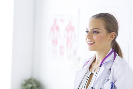 Smiling female doctor with a medical stethoscope in uniform standingの写真素材