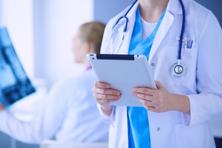 Close up shoot of doctor with tablet and colleague with x-ray on the background.の写真素材