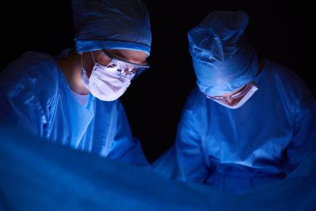 Doctors team in surgery in a dark background.