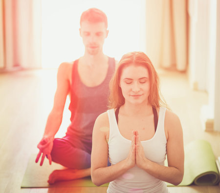 Young athletic couple practicing acroyoga. Balancing in pair.の写真素材