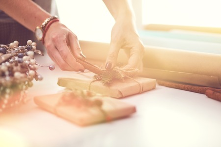 Hands of woman decorating christmas gift box.の写真素材