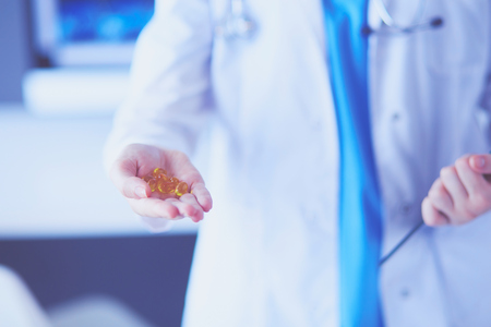 Close-up shot of doctor's hands holding pillsの写真素材