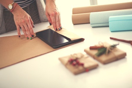 Hands of woman decorating christmas gift box. Hands of woman.の写真素材