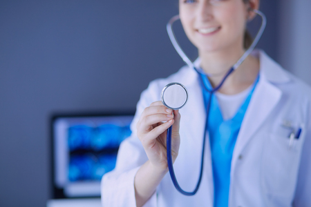 Close-up shot of doctors hands holding stethoscope at clinic.の写真素材