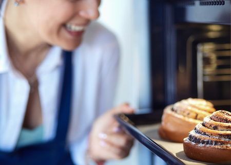 Woman cook holding plate with homemade baked goodsの写真素材