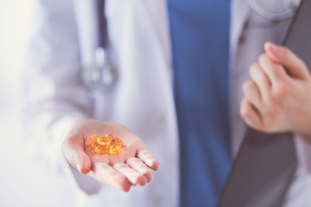 Close-up shot of doctors hands holding pills.の写真素材
