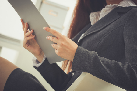 Young happy businesswoman in office holding a folderの写真素材