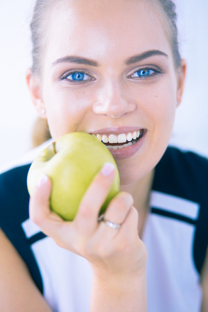 Close up portrait of healthy smiling woman with green apple.の写真素材