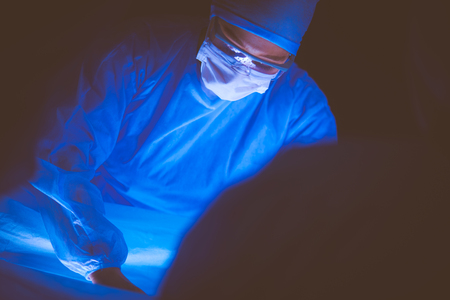 Doctors team in surgery in a dark background.の写真素材