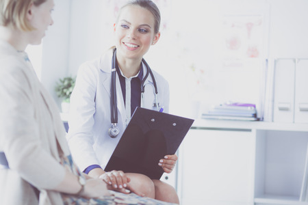 Doctor and patient discussing something while sitting at the table . Medicine and health care conceptの写真素材