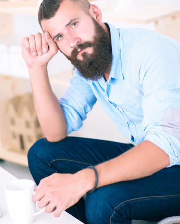 Young businessman sitting on chair in officeの写真素材