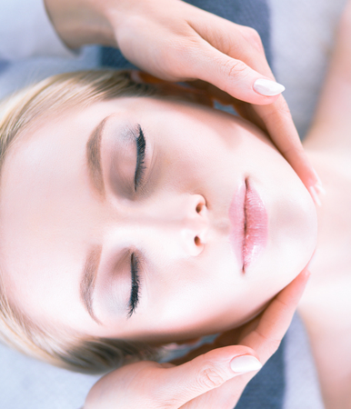 Young woman lying on a massage table,relaxing with eyes closed. Woman. Spa salonの写真素材