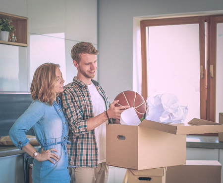 Couple unpacking cardboard boxes in their new home. Young couple.の写真素材