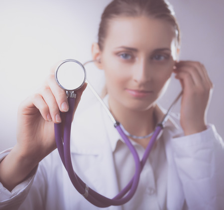 A young female doctor listening ,holding medical stethoscopeの写真素材