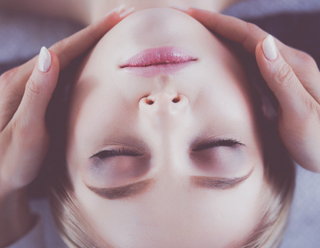 Young woman lying on a massage table,relaxing with eyes closed. Woman. Spa salonの写真素材