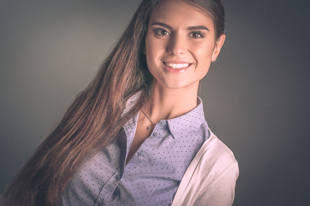 Portrait of a businesswoman , against dark background. Woman smiling. Portrait of a womanの写真素材