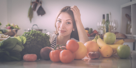 Young woman standing near desk in the kitchenの写真素材