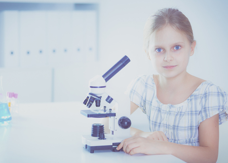 School girl with a microscope in science class.の写真素材