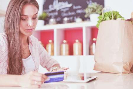 Young woman in the kitchen, using her tablet.の写真素材