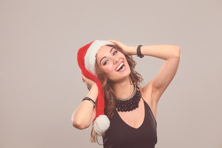 Portrait of a beautiful woman wearing a santa hat smiling.の写真素材