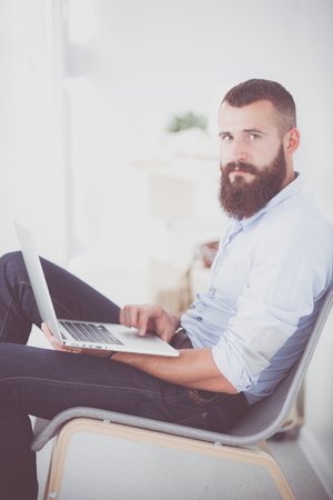 Young businessman sitting on chair in officeの写真素材