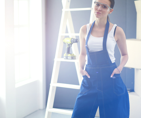 Worker woman with drill standing in new homeの写真素材