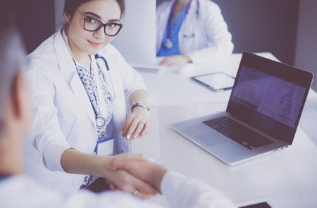 Serious medical team using a laptop in a bright officeの写真素材