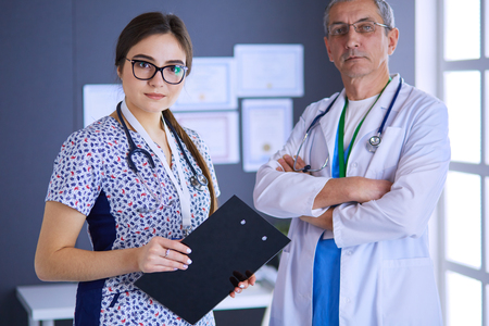 A medical team of doctors, man and woman,standing in officeの写真素材