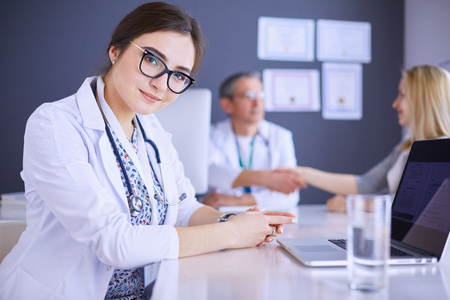 Doctor and patient discussing something while sitting at the table . Medicine and health care conceptの写真素材