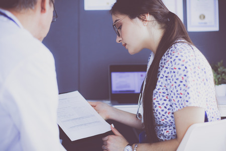 Two doctors speaking in a bright officeの写真素材