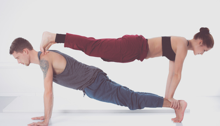 Young athletic couple practicing acroyoga. Balancing in pair.の写真素材