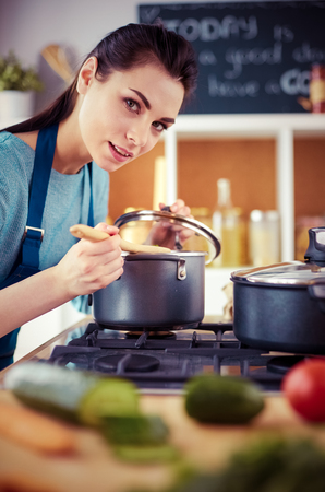 Cooking woman in kitchen with wooden spoonの写真素材