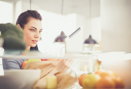Smiling woman taking a fresh fruit out of the fridge, healthy food conceptの写真素材