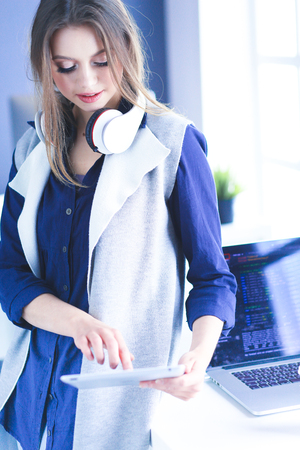 Young confident businesswoman working at office desk and typing with a laptopの写真素材