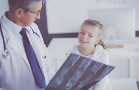 Portrait of a cute little girl and her doctor at hospitalの写真素材