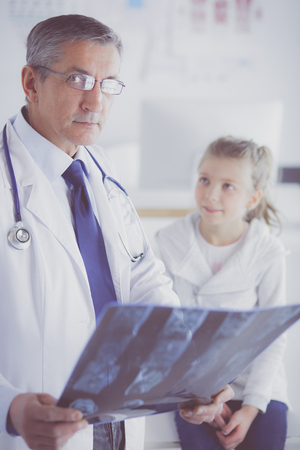 Portrait of a cute little girl and her doctor at hospitalの写真素材