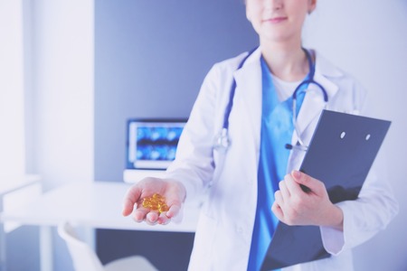 Close-up shot of doctors hands holding pills at clinic.の写真素材